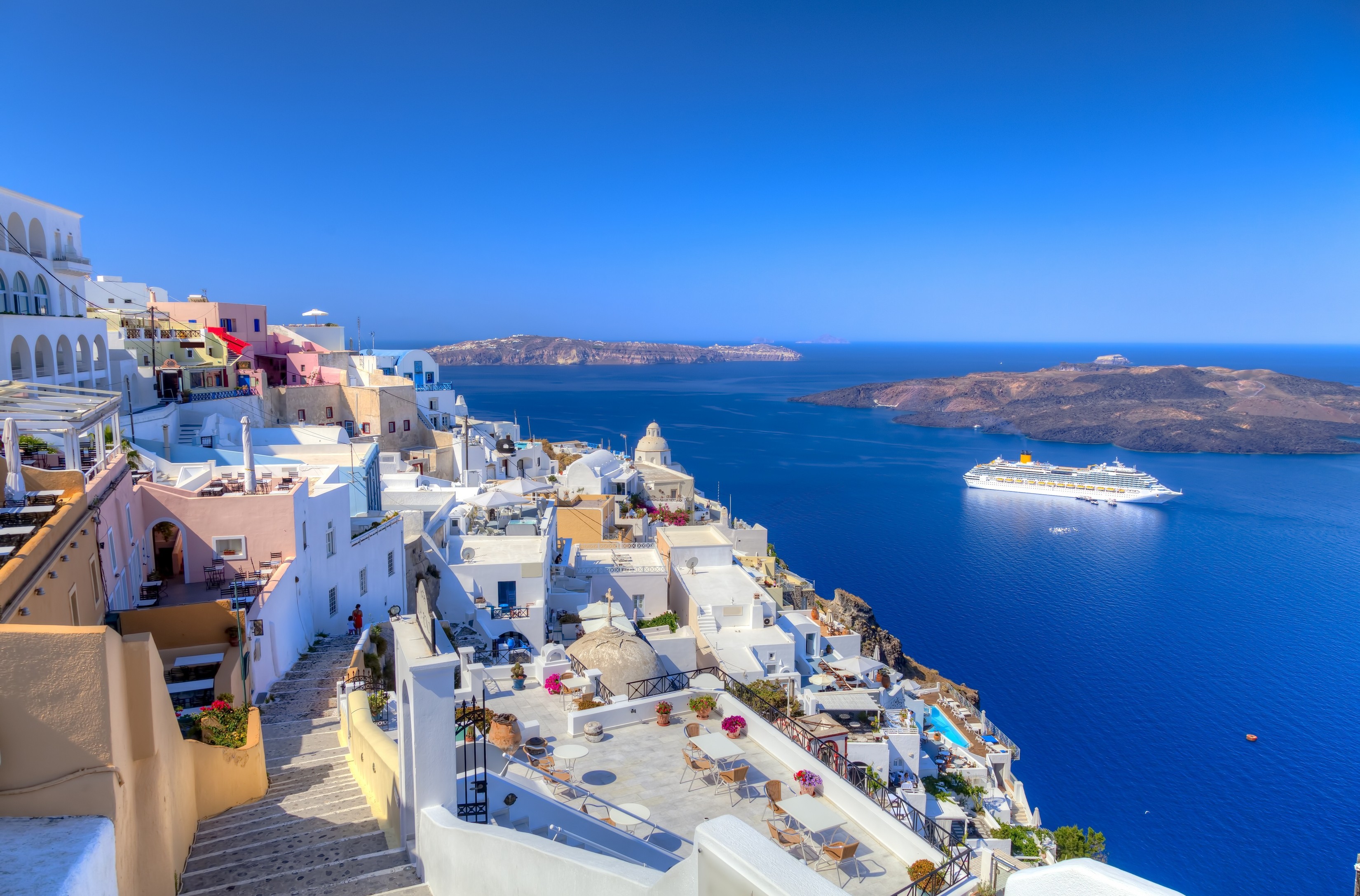 Vita hus på Santorini med kryssningsfartyg i Egeiska havet, Grekland